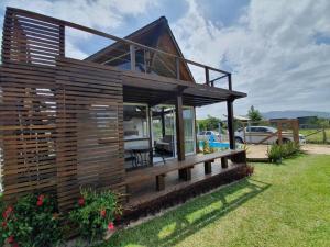 a small wooden house in a yard at Descanso do Rosa - cabanas charmosas in Imbituba