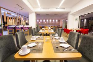 uma sala de jantar com mesas e cadeiras de madeira em Holiday Inn San Salvador, an IHG Hotel em San Salvador