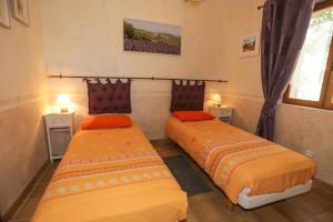 dwa łóżka w pokoju z oknem w obiekcie Santolines en Provence w mieście Piolenc