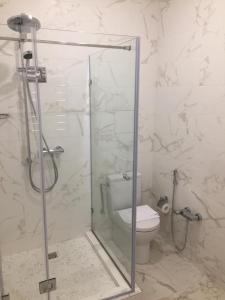 a bathroom with a glass shower with a toilet at Union Hotel Grozny in Groznyy