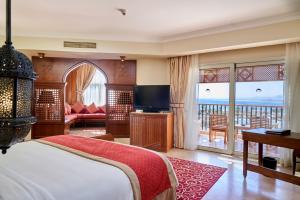 a bedroom with a bed and a view of the ocean at Kempinski Hotel Soma Bay in Hurghada