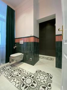 La salle de bains est pourvue de toilettes et d'un rideau vert. dans l'établissement Nordischer Hof Apartments, à Toruń