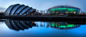 un gran edificio de cristal junto a un cuerpo de agua en Holiday Inn Express - Glasgow Airport, an IHG Hotel en Paisley