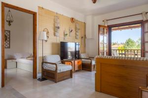 a living room with a flat screen tv and a couch at Cielle Epoque in Pefkohori