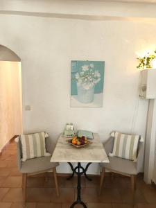 een tafel met twee stoelen en een vaas met bloemen bij Market in Antibes