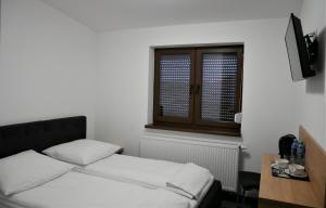 a bedroom with a bed and a desk and a window at Alda Gold in Pyrzowice