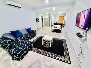 Il comprend un salon doté d'un canapé et d'une télévision à écran plat. dans l'établissement Huda Homestay @ Port Dickson, à Port Dickson