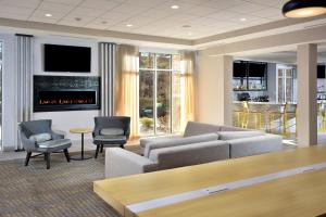 Holiday Inn Raleigh Durham Airport, an IHG Hotel في موريسفيل: غرفة معيشة مع أريكة ومدفأة