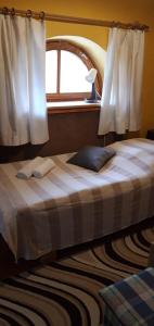 a bedroom with a large bed with a window at Agave Apartman in Velence