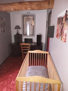 Quettehou的住宿－胡博德里度假屋，一张带桌子和椅子的房间里婴儿床