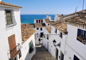 an alleyway between buildings with the ocean in the background at Casco Antiguo 1 Piscina, Terraza y Parking by Vero in Altea