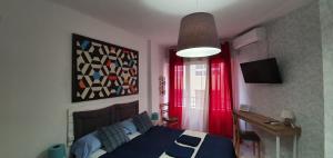 a bedroom with a blue bed and red curtains at Centric Rooms Mercado in Alicante