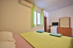 een slaapkamer met een bed met groene lakens en een raam bij Room 4 Two in Bol