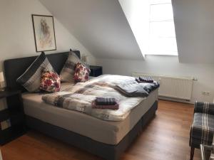 a bed with pillows on it in a room at Altstadt Apartment Augustiner in Erfurt