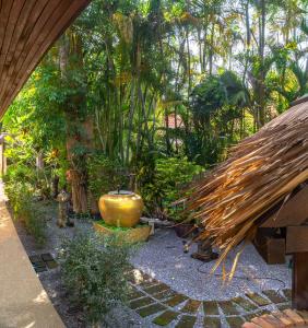 a garden with a large yellow vase in the middle at Coconut Paradise Villas in Rawai Beach