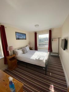 Un dormitorio con una cama grande y una ventana. en Mary Green Walk, en Canterbury