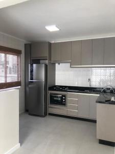 eine Küche mit einem Kühlschrank und Geräten aus Edelstahl in der Unterkunft Apartamento 3100 in Balneário Camboriú