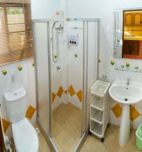 a bathroom with a shower and a toilet and a sink at Coconut Paradise Villas in Rawai Beach