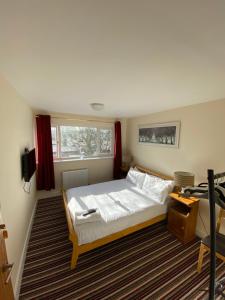 Un dormitorio con una cama grande y una ventana. en Mary Green Walk, en Canterbury
