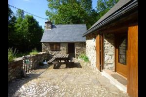 a picnic bench in front of a stone building at artiguelongue grange restaurée in Loudenvielle