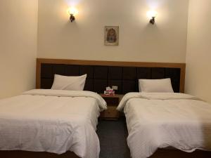 two beds in a room with white sheets and lights at Draz pyramids view Bed & breakfast in Cairo