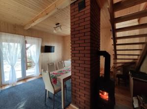 ein Wohnzimmer mit einem Kamin, einem Tisch und Stühlen in der Unterkunft Sunny House in Anielin in Anielin