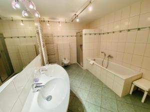 ein Badezimmer mit Waschbecken, Badewanne und Toilette in der Unterkunft Villa Theresa - Ferienwohnung 1 in Heringsdorf