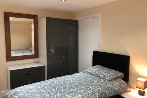 a bedroom with a bed and a mirror at 133B PARK ROAD STRETFORD MANCHESTER in Manchester