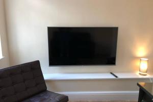 a living room with a large television on a wall at 133B PARK ROAD STRETFORD MANCHESTER in Manchester