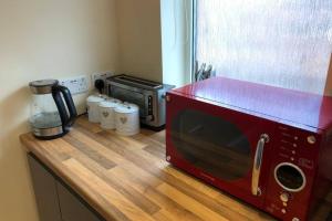 un microondas rojo sentado en la parte superior de una barra de cocina en 133B PARK ROAD STRETFORD MANCHESTER, en Mánchester