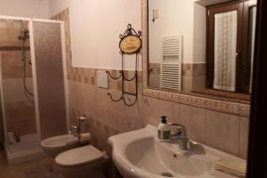 łazienka z umywalką, toaletą i lustrem w obiekcie Residenza Il cortile w mieście Monte San Martino +6 zdjęć