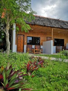 ein Haus mit einem Grasdach in der Unterkunft Native House Resort by Cocotel in Moalboal