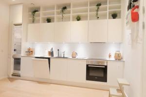 a white kitchen with white cabinets and a stove at Exquisite apartment, most convenient location, Apt 5. in Copenhagen