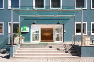 a blue building with stairs leading to a door at Holiday Inn Salerno-Cava De' Tirreni by IHG in Cava deʼ Tirreni