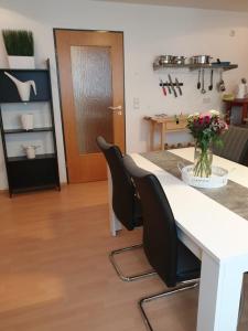 cocina con mesa blanca y sillas negras en City-Appartement Vogel, en Coblenza