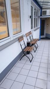 2 chaises assises sur la terrasse couverte d'une maison dans l'établissement City-Appartement Vogel, à Coblence