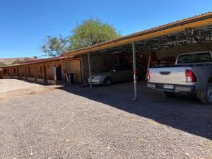 dos autos estacionados en un estacionamiento al lado de un edificio en Las Cornizas de Catarpe, en San Pedro de Atacama
