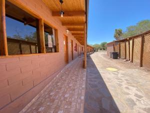 un couloir vide d'un bâtiment avec une clôture dans l'établissement Las Cornizas de Catarpe, à San Pedro de Atacama