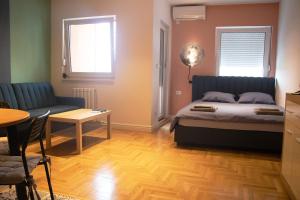 a bedroom with a bed and a couch and a table at TiTo in Belgrade