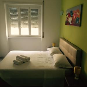 1 dormitorio con 1 cama con toallas en Affittacamere Roma Tiburtina, en Roma