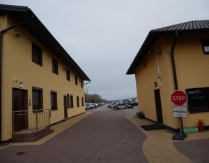 a stop sign in a parking lot next to two buildings at Alda in Pyrzowice