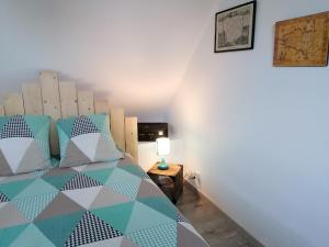 a bedroom with a bed and a lamp on a table at Chez Jak et Laurent in Quéven