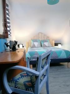 um quarto com uma cama, uma cadeira e uma mesa em Chez Jak et Laurent em Quéven