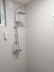 a shower in a bathroom with white tiles at Airport view Apartment in Belgrade