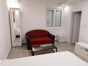 a living room with a red chair and a table at Airport view Apartment in Belgrade