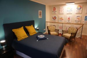 ein Schlafzimmer mit einem Bett mit gelben Kissen und 2 Stühlen in der Unterkunft Duplex Rue Haute in Laneuveville-derrière-Foug