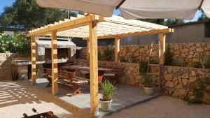 a wooden pergola with a picnic table and a bench at Carpe Diem**** in Lun