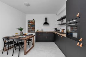 a kitchen with a wooden table and black cabinets at Apartment Lotte with private pool in the city center! in Makarska