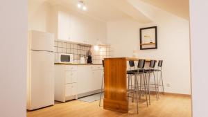 a kitchen with white cabinets and a white refrigerator at Beija Mar in Vila Franca do Campo
