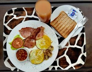 a plate of breakfast food with eggs bacon beans and toast at SnL 38 Hoep Hoep in Malelane